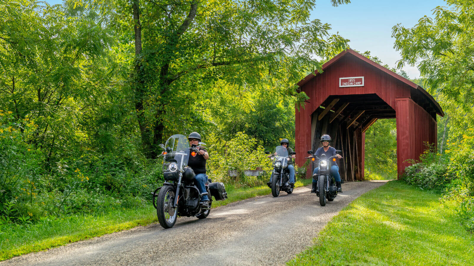 Motorcycles crossing a coverd bridge